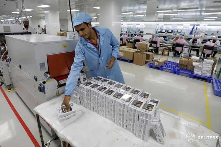 A worker is seen next to mobile phone packages in Assuit